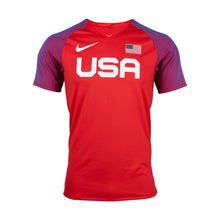 A red Nike throw top with 'USA' text and the American flag, featuring the Nike swoosh logo and a flag patch on the chest.