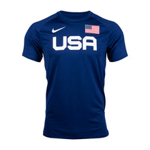A blue Nike men's warm-up T-shirt with bold 'USA' lettering on the front and an American flag next to the brand's swoosh logo.