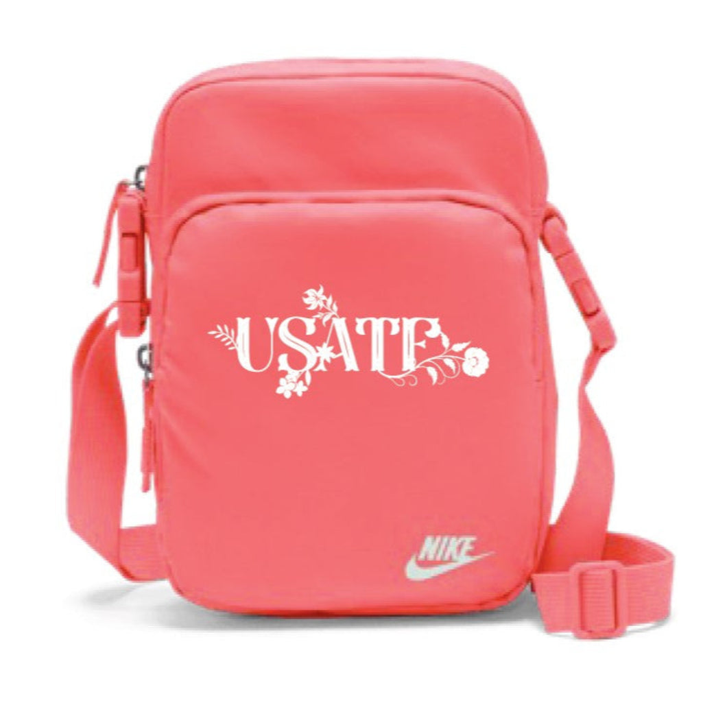 Pink crossbody bag with 'USATF' and Nike logo on a white background